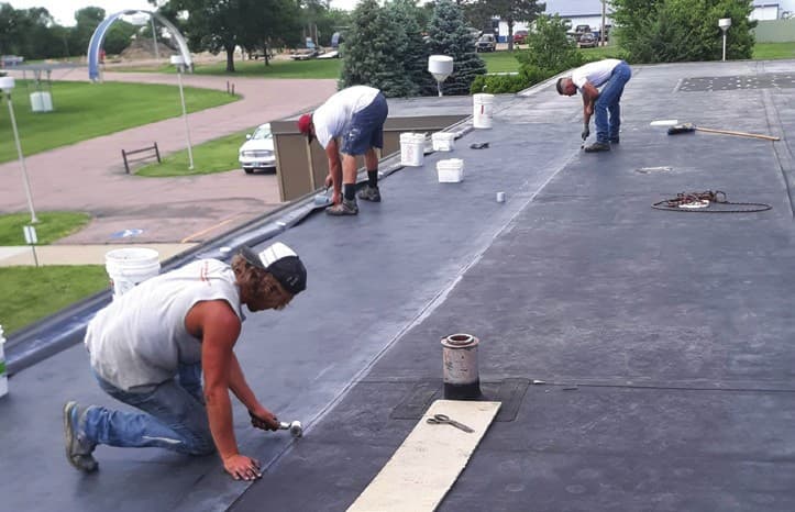 A-1 crew repairing saturated and delaminated areas of the EPDM membrane at Colome Elementary School