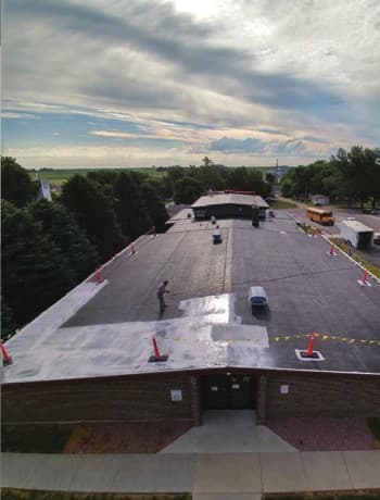 Aerial view of two-part epoxy primer being applied across the Colome Elementary School roof