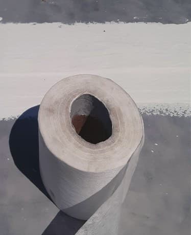 Roll of polyester mesh used to reinforce seams and details on the primed Colome Elementary School roof