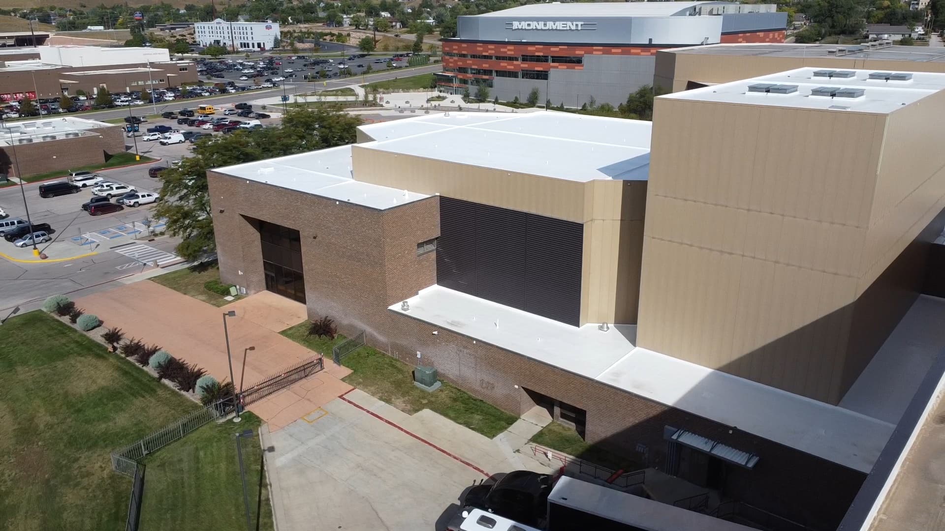 Aerial view of the completed white silicone restoration across the stepped roof levels at The Monument in Rapid City, South Dakota