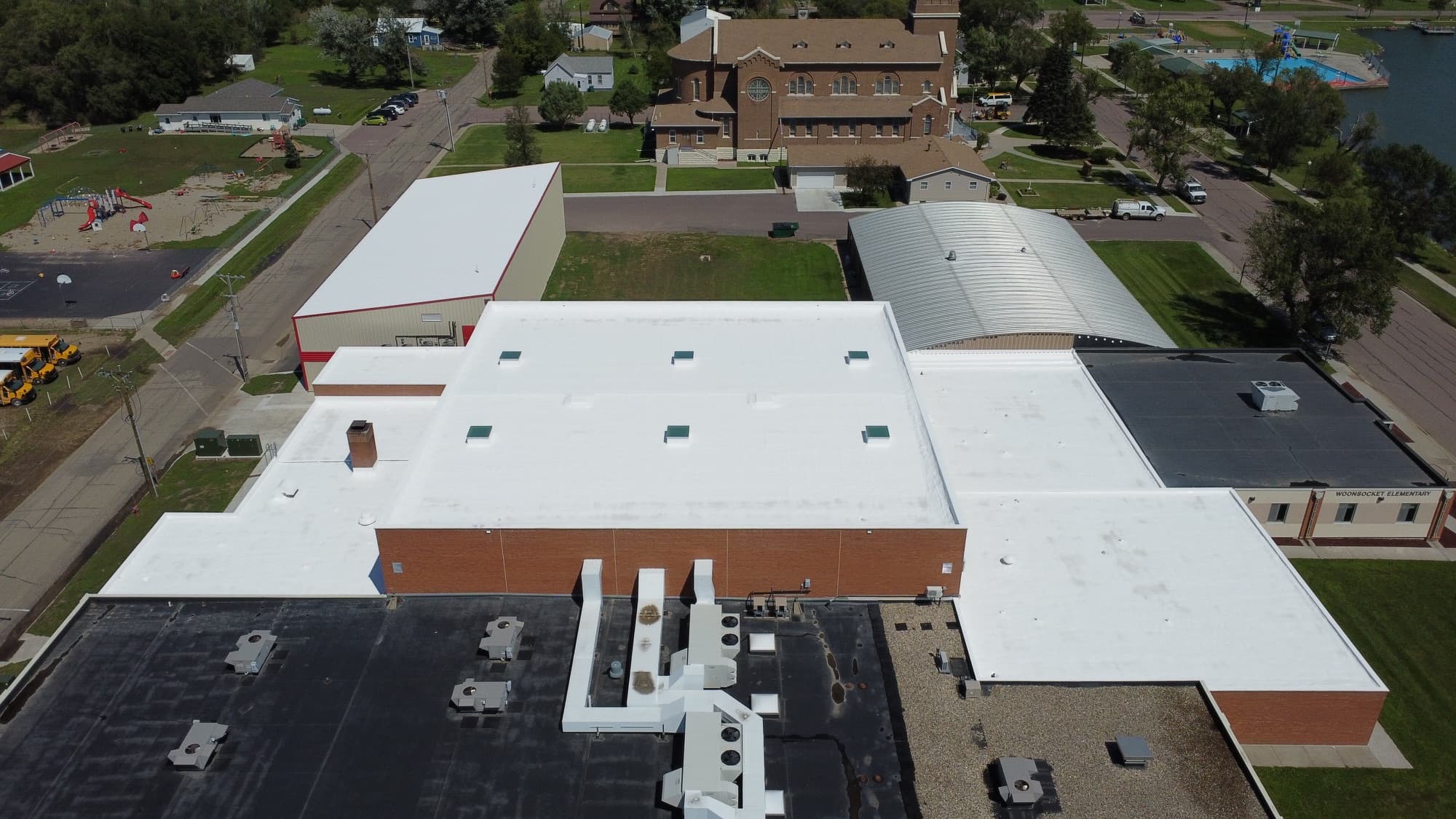 Aerial view of the restored white spray foam roof on the Woonsocket School District buildings in Woonsocket, South Dakota